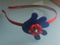 Diadema roja con detalle de fieltro azul y flor de fimo en rojo 4€.